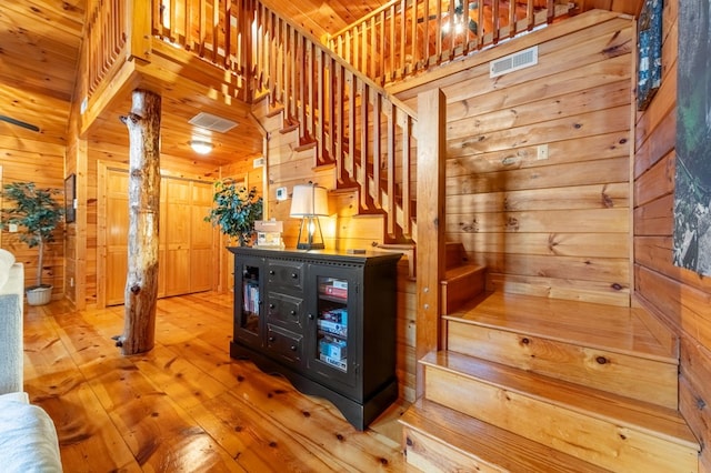 interior space with hardwood / wood-style flooring, wooden ceiling, and wooden walls