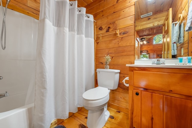 full bathroom featuring hardwood / wood-style floors, shower / tub combo with curtain, wood walls, vanity, and toilet