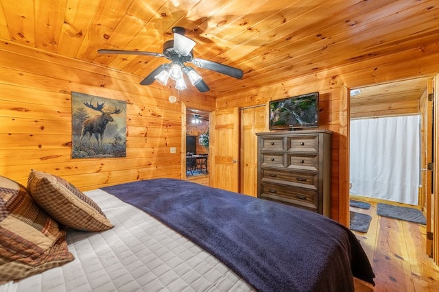 bedroom with wood ceiling, ceiling fan, and wooden walls