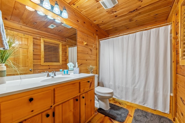 bathroom featuring wood walls, wood-type flooring, vanity, toilet, and wooden ceiling