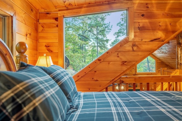 bedroom featuring vaulted ceiling, wooden ceiling, and wood walls