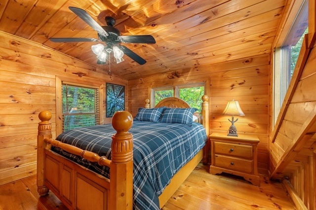 bedroom with wood ceiling, ceiling fan, wooden walls, vaulted ceiling, and light wood-type flooring