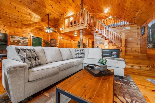 living room with high vaulted ceiling, wooden ceiling, hardwood / wood-style floors, and wood walls