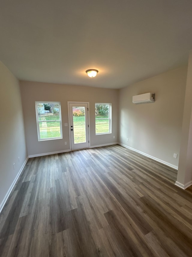 interior space featuring an AC wall unit and dark wood-type flooring