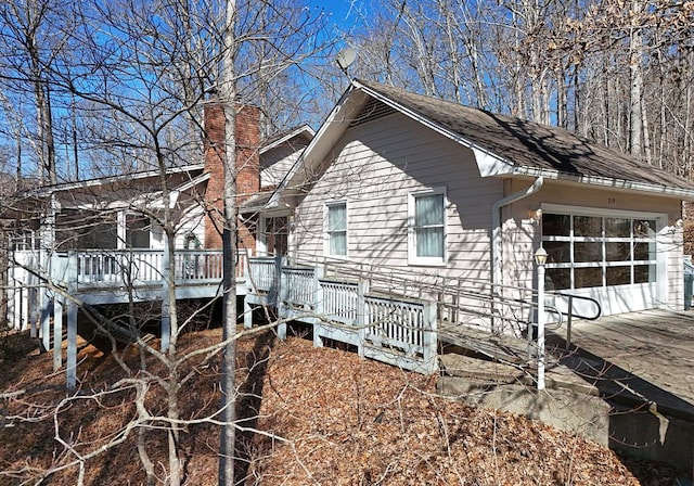 view of property exterior with a garage and a deck