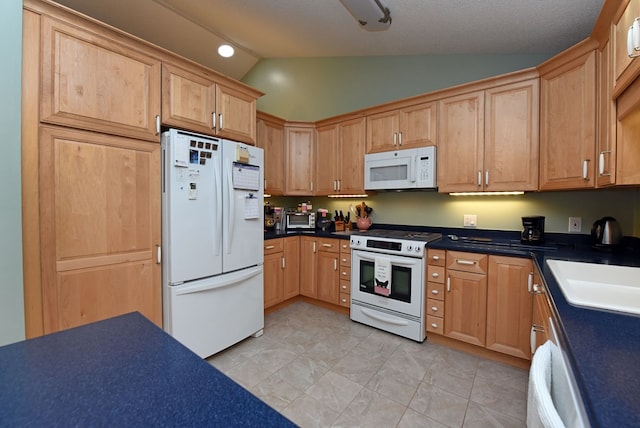 kitchen with appliances with stainless steel finishes, sink, and vaulted ceiling