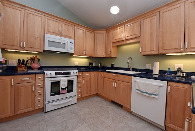 kitchen with lofted ceiling, sink, and white appliances