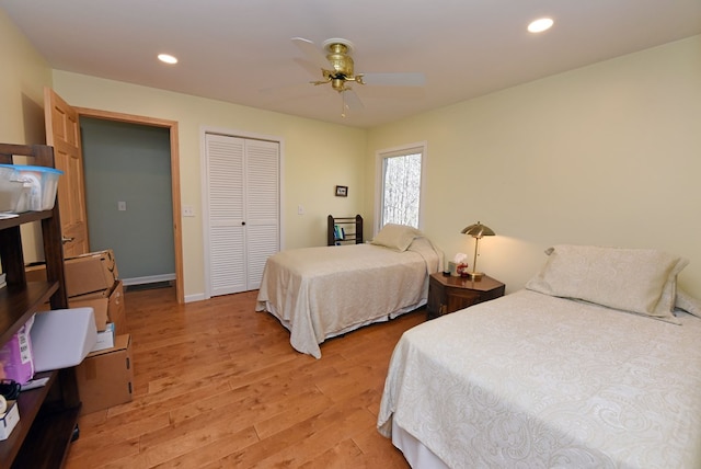 bedroom featuring ceiling fan, light hardwood / wood-style floors, and a closet