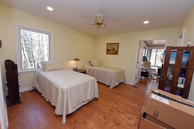 bedroom featuring multiple windows, wood-type flooring, and ceiling fan