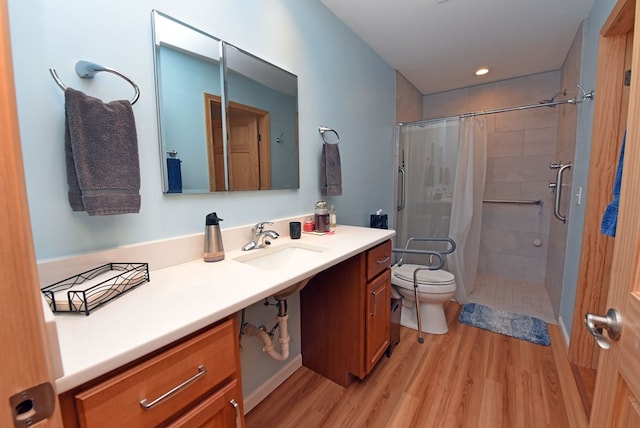 bathroom with wood-type flooring, toilet, curtained shower, and vanity