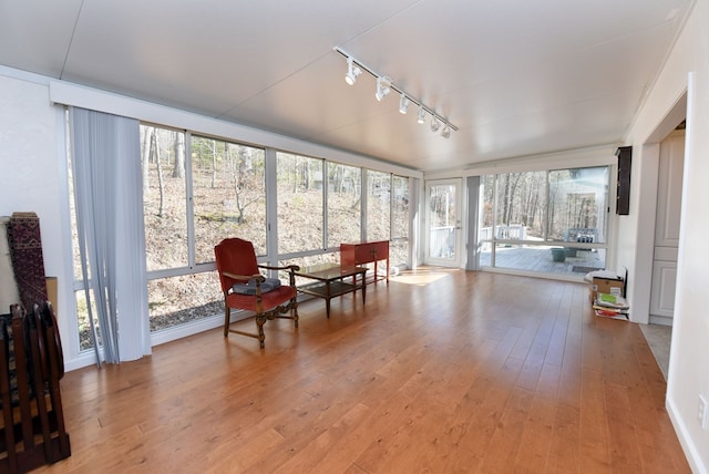 sunroom / solarium featuring rail lighting