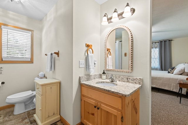 bathroom with vanity, toilet, and a textured ceiling