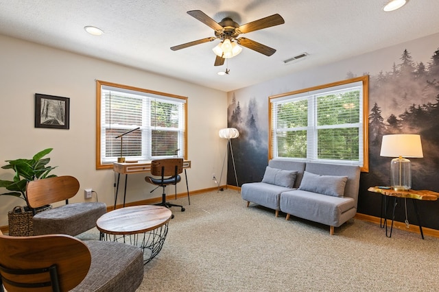 living area with carpet floors, a textured ceiling, and ceiling fan