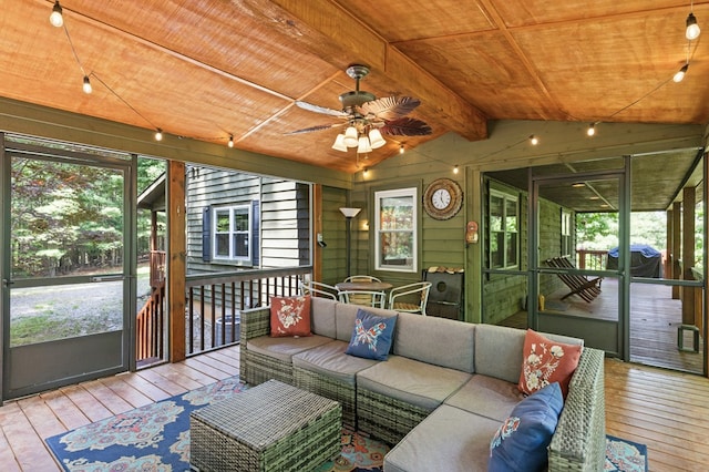 sunroom with lofted ceiling with beams, wooden ceiling, and ceiling fan