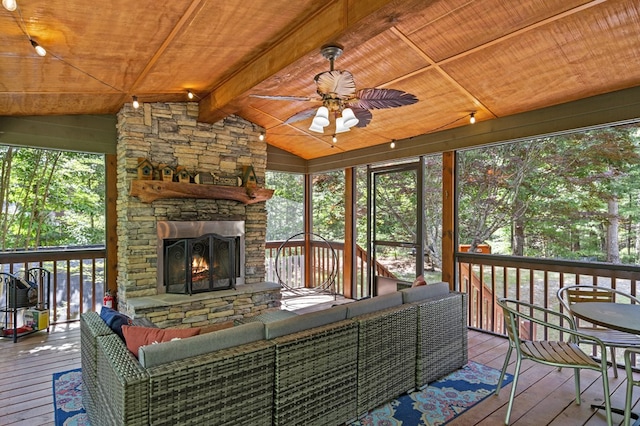 wooden terrace featuring ceiling fan and an outdoor living space with a fireplace