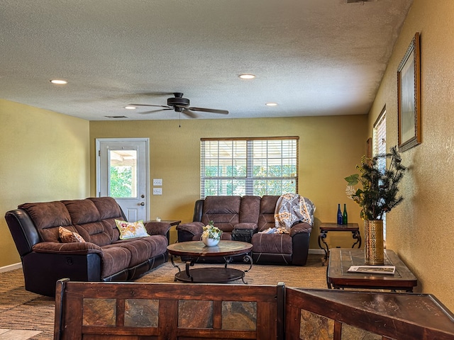 carpeted living room featuring a textured ceiling and ceiling fan