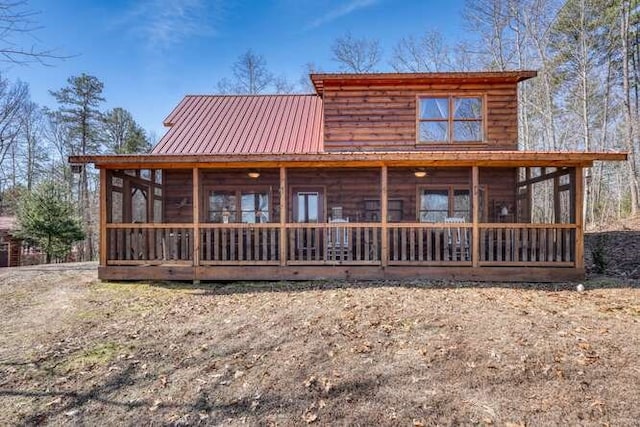 back of house featuring metal roof and a sunroom