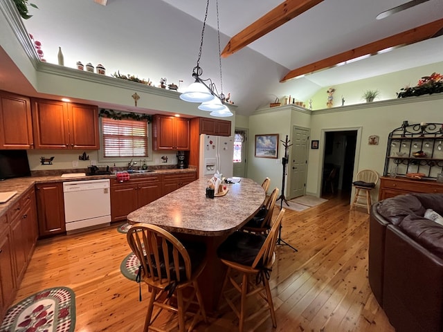 kitchen featuring a center island, lofted ceiling with beams, light hardwood / wood-style floors, decorative light fixtures, and white appliances