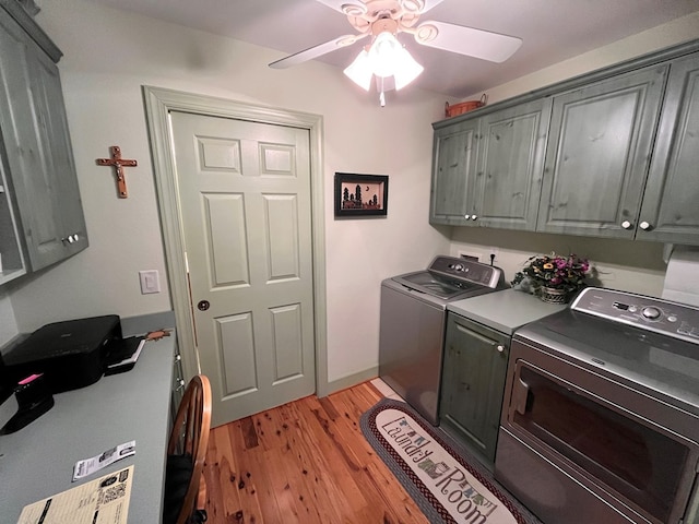 laundry room featuring washing machine and clothes dryer, ceiling fan, cabinets, and light wood-type flooring