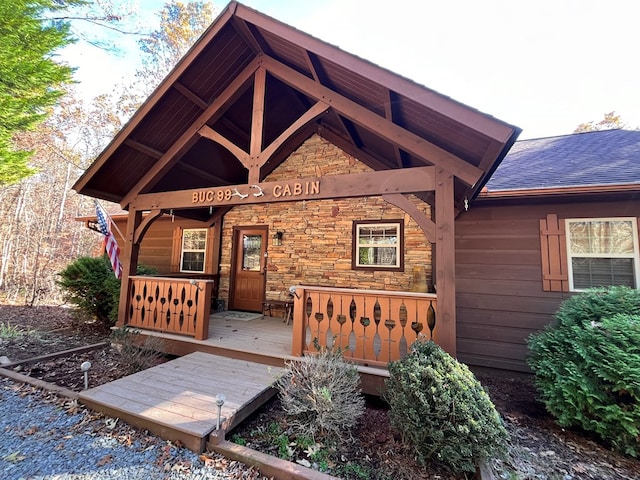 199 Orlon Dr, East Ellijay, GA 30540 - view of exterior entry with stone siding, a porch, and roof with shingles