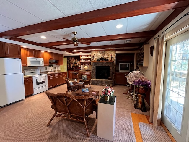 carpeted living room with a fireplace, beam ceiling, ceiling fan, and sink