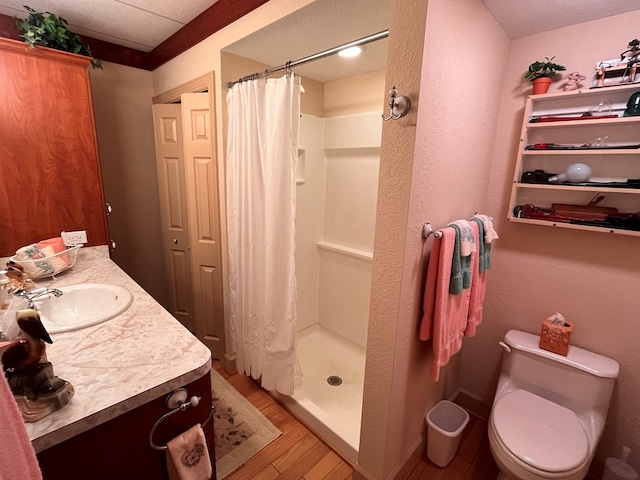 bathroom with a shower with curtain, vanity, hardwood / wood-style flooring, and toilet