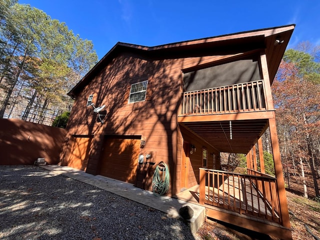 rear view of property with a garage and a balcony