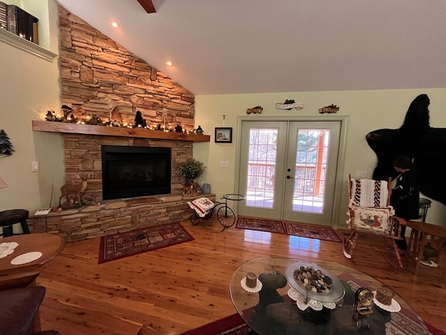 living room featuring a fireplace, french doors, vaulted ceiling, and hardwood / wood-style flooring