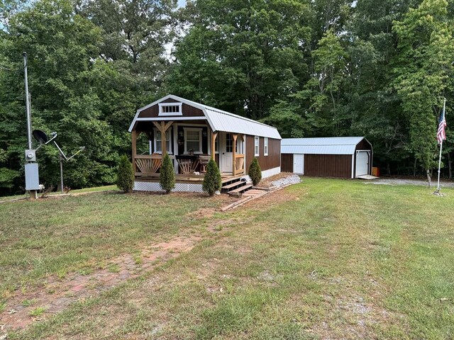 view of front of property featuring a front yard, an outdoor structure, and a garage