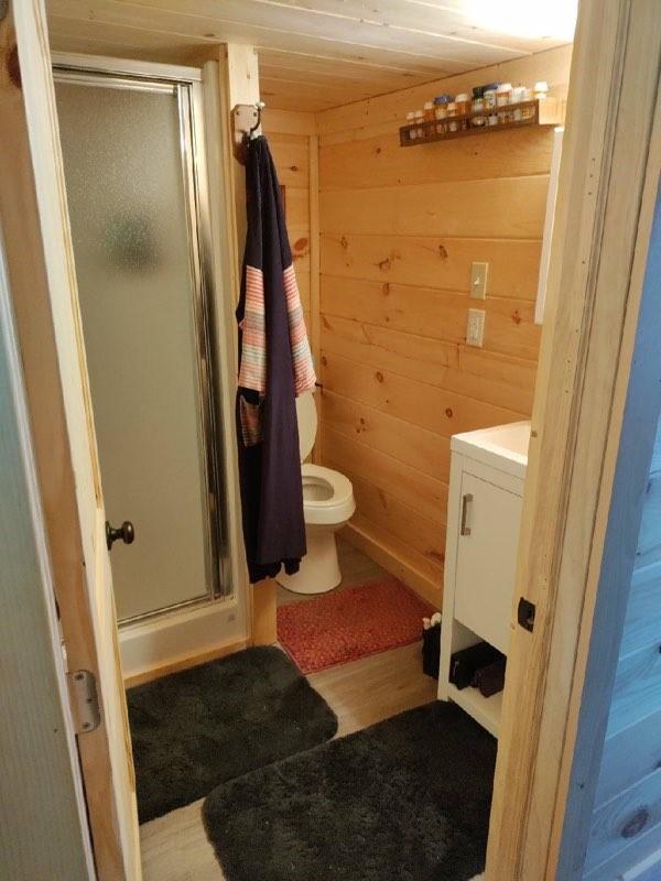 bathroom featuring vanity, a shower with door, and wooden walls