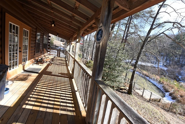 deck with a water view and french doors