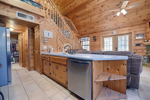 kitchen featuring sink, wood walls, and stainless steel appliances