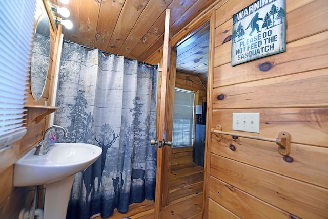 bathroom with wood walls, wood ceiling, and vaulted ceiling