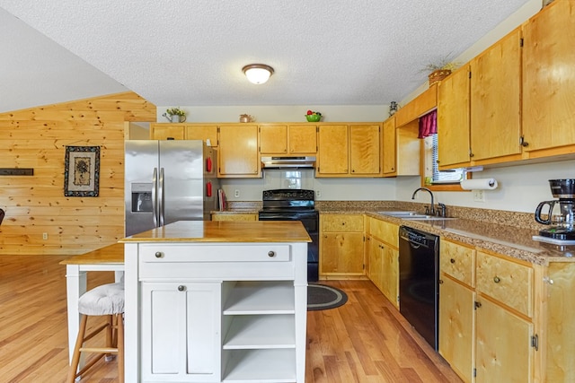 kitchen featuring black appliances, a sink, open shelves, wooden walls, and light wood finished floors