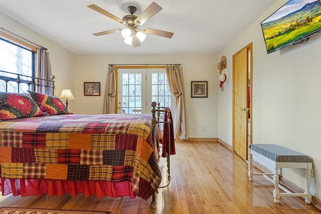 bedroom featuring baseboards, ceiling fan, access to exterior, wood-type flooring, and a textured ceiling