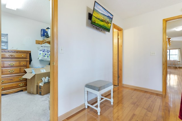 hall featuring hardwood / wood-style flooring, baseboards, and a textured ceiling