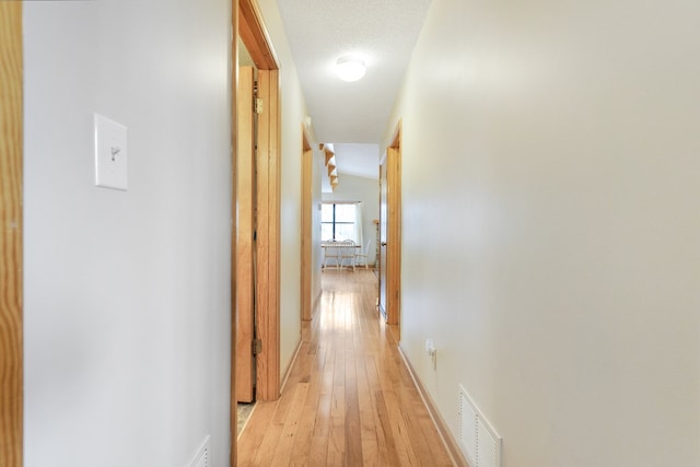 hall featuring visible vents and light wood finished floors