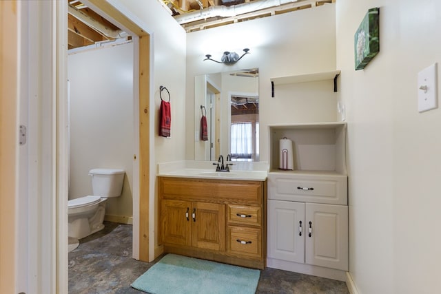 bathroom featuring toilet, vanity, and baseboards