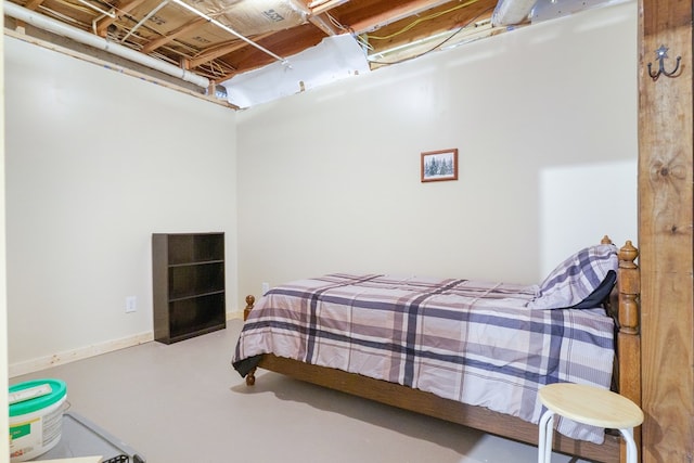 bedroom with finished concrete flooring and baseboards