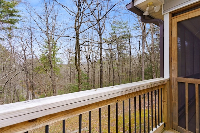 wooden terrace featuring a forest view