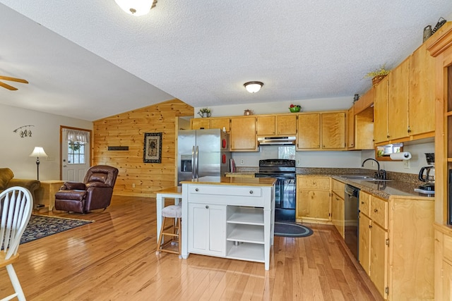 kitchen featuring a sink, range with electric cooktop, stainless steel fridge, under cabinet range hood, and open floor plan