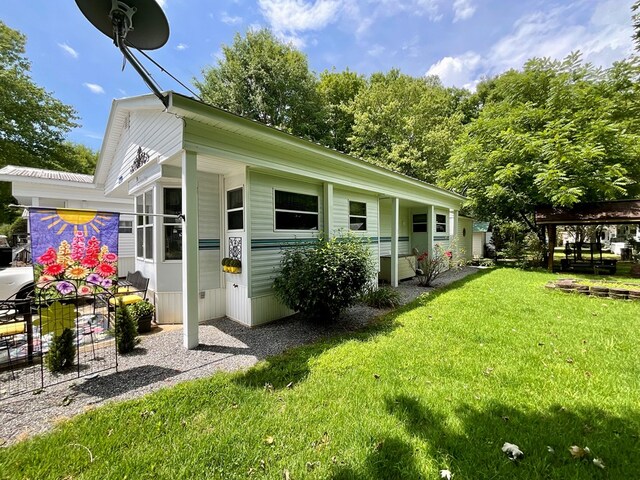 rear view of house featuring a lawn