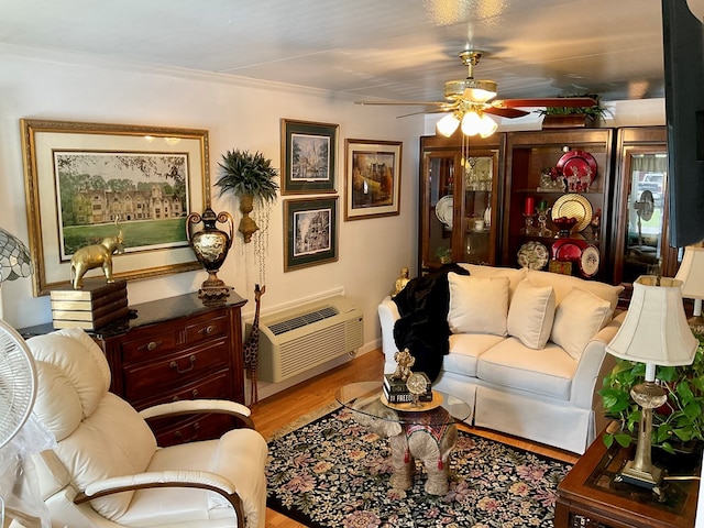 living room featuring ornamental molding, light hardwood / wood-style flooring, a wall mounted air conditioner, and ceiling fan