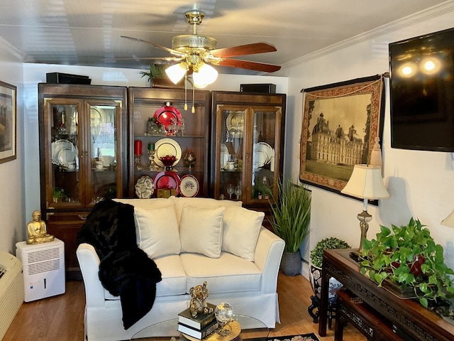 living room with crown molding, wood-type flooring, and ceiling fan