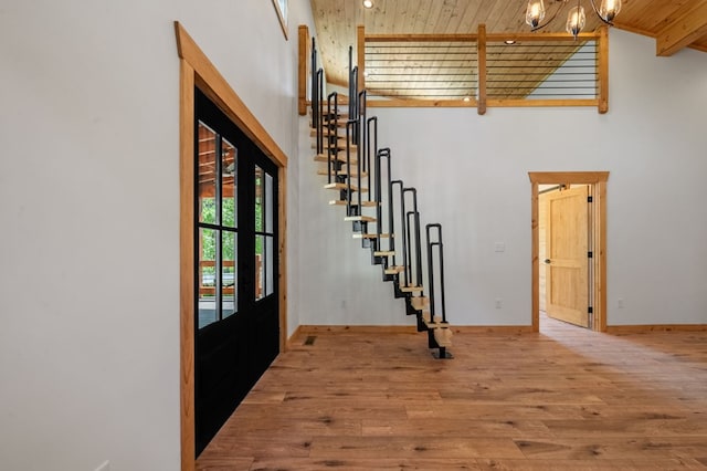 foyer featuring light hardwood / wood-style flooring, beamed ceiling, wood ceiling, and high vaulted ceiling