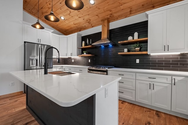 kitchen featuring appliances with stainless steel finishes, light hardwood / wood-style floors, white cabinetry, and pendant lighting