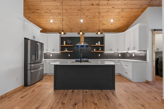 kitchen with white cabinets, decorative light fixtures, light wood-type flooring, and stainless steel appliances