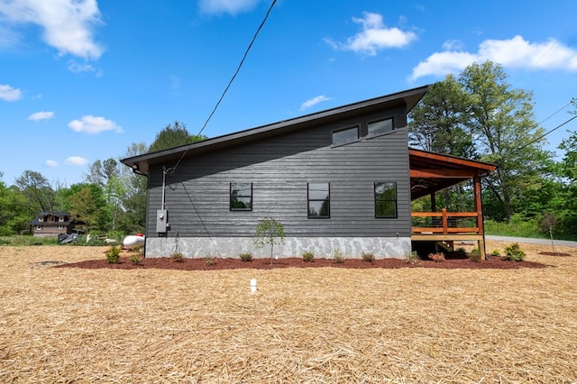 view of property exterior with a wooden deck