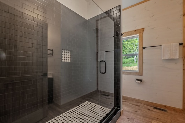 bathroom featuring hardwood / wood-style flooring and a shower with door