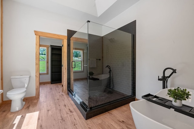 bathroom featuring hardwood / wood-style floors, separate shower and tub, and toilet